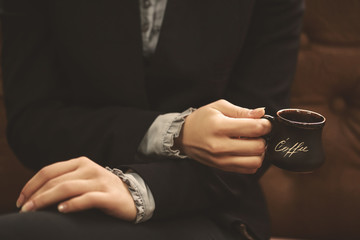 cup of coffee in female hand close-up, business lunch