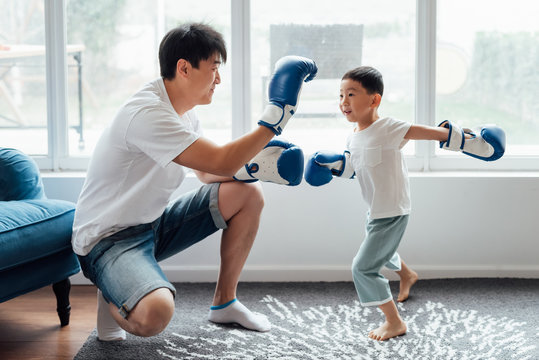 Father and son playing boxing at home