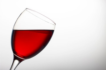 Wineglass with red wine close-up isolated on light background, copy space