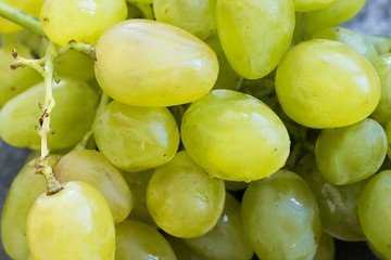 Ripe green grapes close-up on a blue shabby concrete background