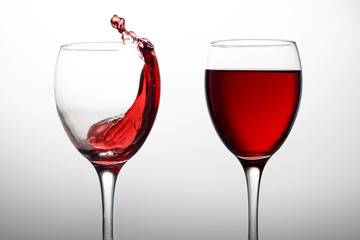 Two glasses with red wine in crystal glasses on a white background close-up