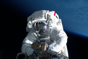 Astronaut in outer space is shooting the Earth. Elements of this image were furnished by NASA