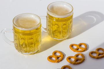 Octoberfest concept. Beer mug with snacks of salt pritzels, bretzel on a white background.