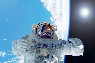 Astronaut in space against the background of the earth. Elements of this image were furnished by...