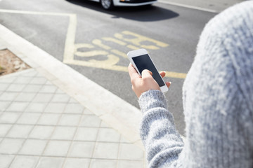 Female hands using smartphone street.