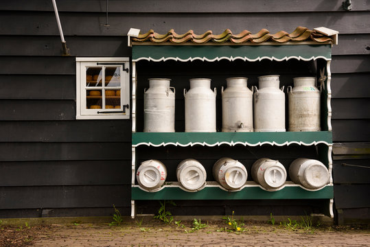 Milk bucket in shelf against house wall in countryside yard