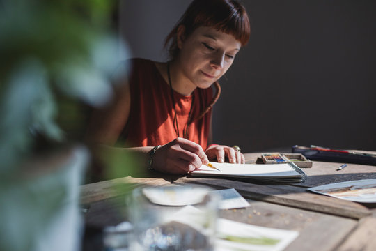 Painter working on watercolour in her studio