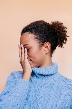 Afro woman covering her face