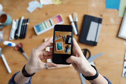 Crop artist taking photo of workspace