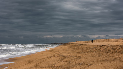 A lonely man walks along the sea coast