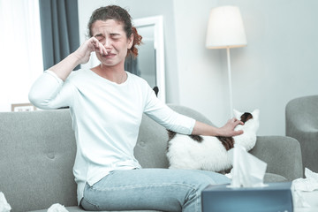 Young red-haired woman feeling awful having allergy to cats