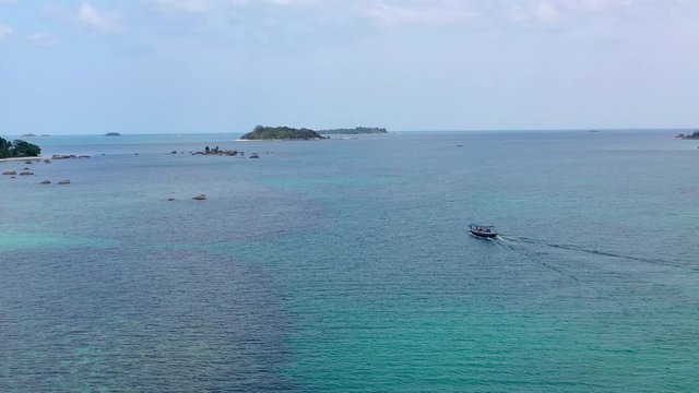 4K Aerial flying over beautiful bay of Tanjung Kelayang of Belitung Island. view of wooden boats, white sandy beach, tree, clear water, cloud and sky