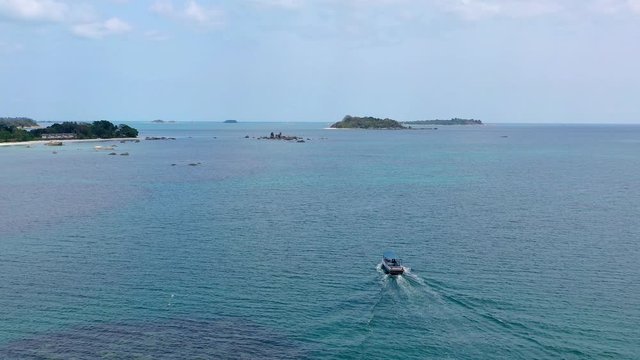 4K Aerial flying over beautiful bay of Tanjung Kelayang of Belitung Island. view of wooden boats, white sandy beach, tree, clear water, cloud and sky
