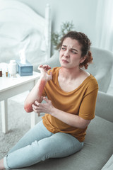 Woman wearing jeans and orange shirt having scratches on arm