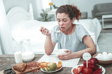 Woman having allergy to some ingredients during breakfast