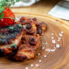 Close up view on tasty grilled steak from chicken on wooden board. Composition with cooked beef, herbs and vegetables. Food photo background. Selective focus. Shashlik, kebab
