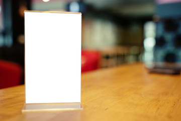 Mock up Menu frame standing on wood table in Bar restaurant cafe. space for text