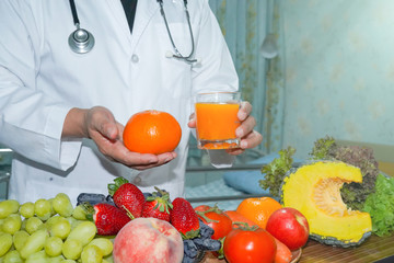 Nutritionist doctor holding orange juice with strawberry, potatoes, apples, plum, grapes, carrot, peach, pumpkin and salad vegetable on desk to instruction healthy food strong patient..