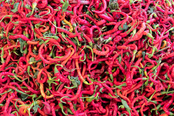 Fototapeta premium Red hot pepper vegetables stacked on a surface as background.