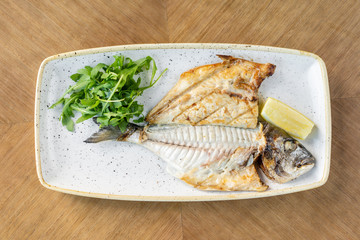 Plate Dorado with arugula and lemon. BBQ seafood. Restaurant menu