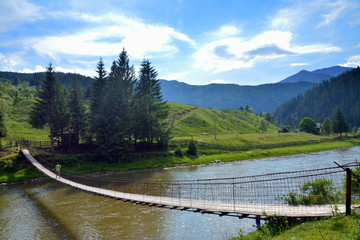 Fototapeta premium a bridge suspended over a mountain river