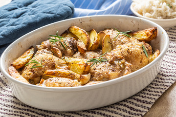 Chicken legs roasted with american potatoes in baking dish