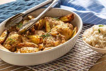 Chicken legs roasted with american potatoes in baking dish