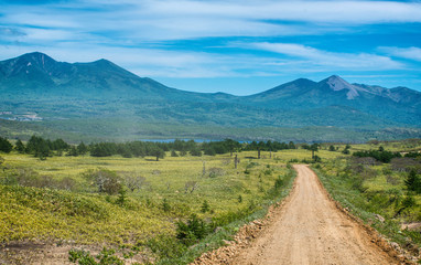 Fototapeta na wymiar A dirt road amid the vast expanses into the distance. Mountain road and sky.