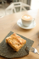 cup of cappuccino with a piece of cake.