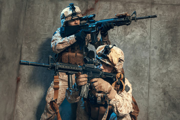 Fototapeta premium US special operations forces fighters armed with assault rifle, in opscore helmet. Studio shot