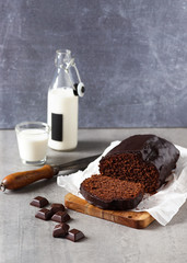 Homemade sweet banana bread with dark chocolate bar on gray rustic background. Selective focus. Copy space.