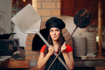 Female Chef in front of Pizza Oven Holding Peels  