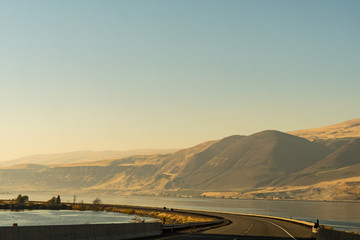 The US-30 highway passing by the Columbia River with water on both sides of the road near The Dalles