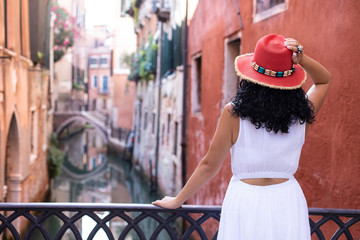 A tourist woman with red hat is looking at Venice Canals. Vacation concept at venice, Italy.