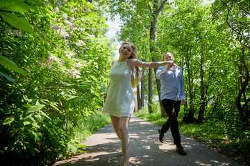 Obraz premium Young man and woman couple walk in the park. Spring or summer love story. Young happy family