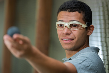 young man wearing goggles and holding a small ball