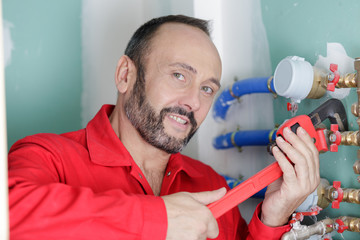 plumber using wrench on water pipe