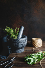 Fresh herbs in a marble mortar on a table. Rustic style food photography.