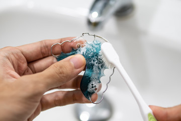 cleaning retainer with toothbrush and toothpaste - obrazy, fototapety, plakaty