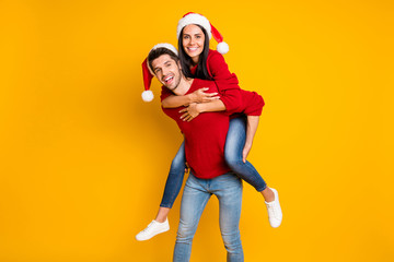 Portrait of cheerful man hug his sweethearts piggyback wear red sweater denim jeans isolated over vivid color background