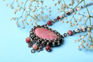 Beautiful silver necklace with rhodonite and tourmaline gemstones on light blue background