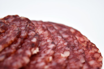 Salami sausage slices isolated on white background.