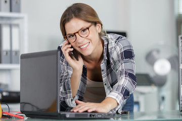 woman with phone and laptop indoors
