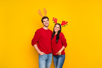 Obraz premium Portrait of two lovely people romantic couple hug enjoy wear elk horns mask red pullover denim jeans isolated over yellow background