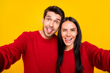 Fototapeta premium Close up photo of cheerful spouses grimace take self portrait wear red sweater isolated over yellow background