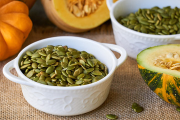 Peeled pumpkin seeds in white bowls 