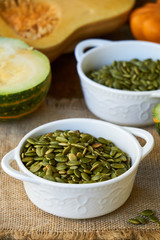 Peeled pumpkin seeds in white bowls 