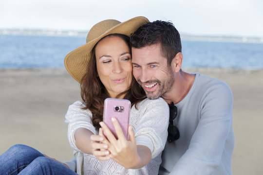 couple taking picture on the beach