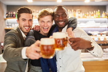 Drei Männer feiern ausgelassen mit Bier