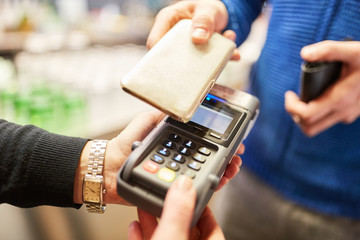Kunde bezahlt mit Smartphone via NFC am Lesegerät